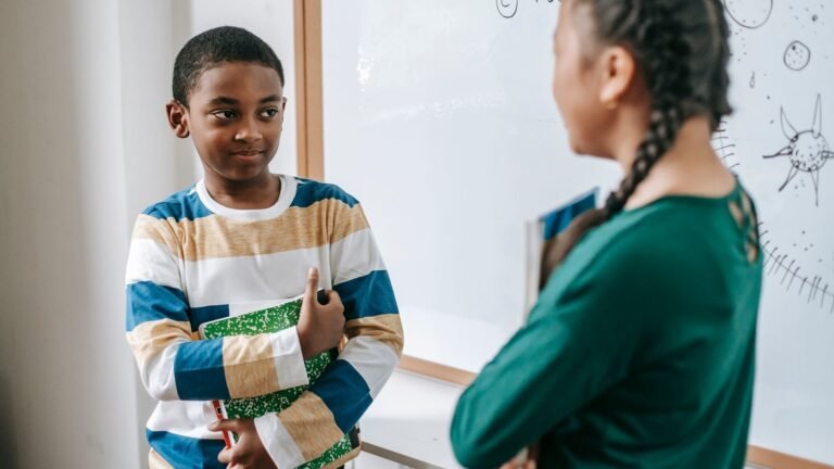 Deux élèves échangeant près d'un tableau dans une classe